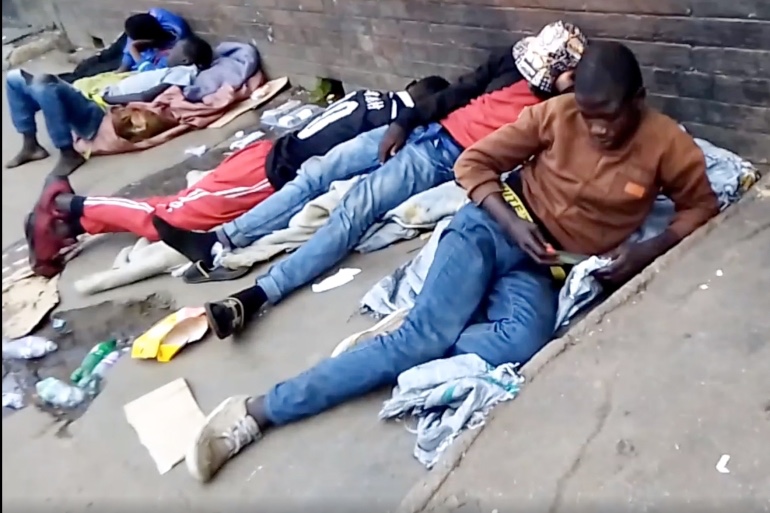 Youths lie down by the road in a suburb of Harare, capital of Zimbabwe, after inhaling sodium polyacrylate